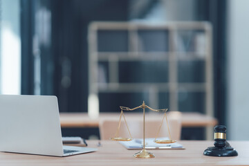 Scales of Justice:  A lawyer's desk, capturing the essence of law and justice with a  golden scale of justice, a gavel, and a laptop. The blurred background signifies the vastness of the legal world.