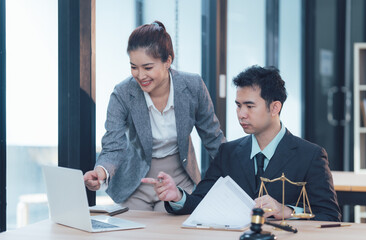 Collaborative Law: A  team of legal professionals discuss legal documents and strategies on a laptop in a modern office setting, showcasing teamwork and professionalism in the legal industry.