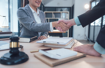 Legal Partnership Handshake: A lawyer and client shake hands in a professional setting, symbolizing trust, agreement, and a successful legal partnership.