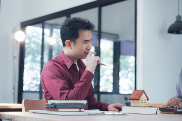 Focused Discussion: A serious and concentrated man, dressed in a burgundy shirt, listens...