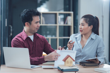 Real Estate Professionals: A male and female real estate agent collaborate over blueprints and a miniature house model, engaging in a serious discussion about a property's details.