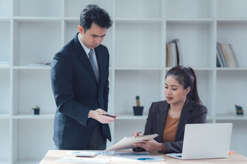 Business Collaboration:  A professional setting showcasing a focused meeting between a male and female colleague, emphasizing teamwork, communication, and collaborative problem-solving. 