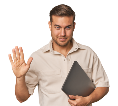 Man holding laptop, studio smiling cheerful showing number five with fingers.