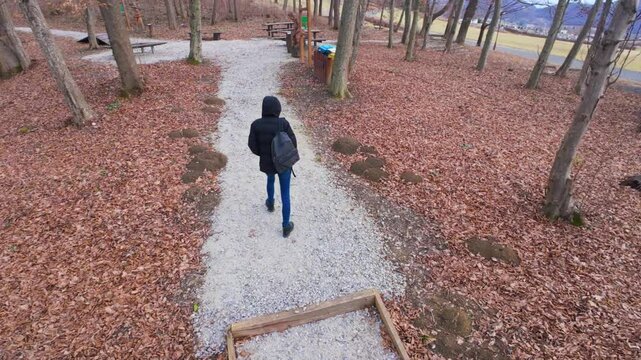 Woman in hooded jacket hiking trough forest at Kumrovec, Croatia, Hrvatsko zagorje, sport and activity, adventure and lifestyle, 4k, aerial,	