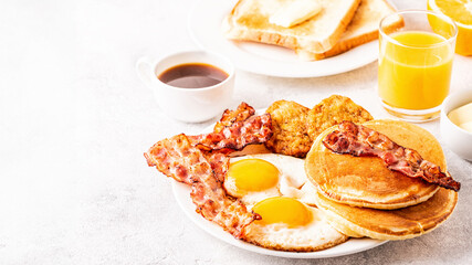Healthy Full American Breakfast with Eggs Bacon Pancakes and Latkes.