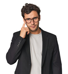 Young Hispanic businessman pointing temple with finger, thinking, focused on a task.
