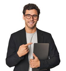 Young Hispanic businessman with laptop smiling and pointing aside, showing something at blank space.