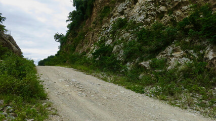 Dirt road in the mountains. Wild road. Wild track. View of the dirt road passing through a rocky gorge.