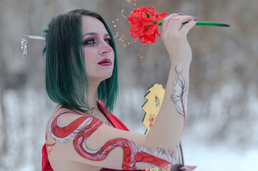 Fototapeta premium European girl with green hair in a red kimono in winter on the street