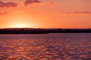 river at sunset, the colorful sky and clouds are reflected on the river