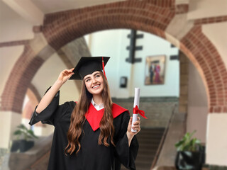 Happy student in academic dress holding diploma after graduation in university
