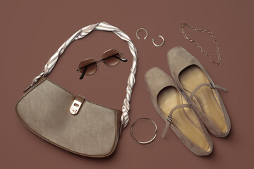 Beautiful bag, shoes and stylish accessories on mocha mousse shade background, flat lay. Trendy...