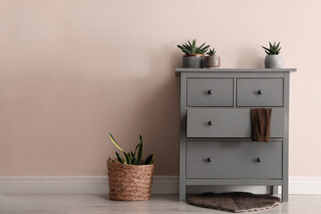 Chest of drawers and decor indoors. Wall in shade of mocha mousse. Stylish interior with trendy color of 2025 year