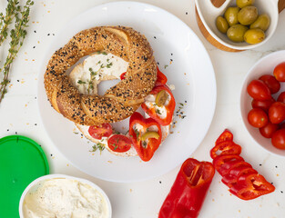 Sesame bagel with cream cheese, peppers, and olives—a vibrant Mediterranean-inspired breakfast or snack