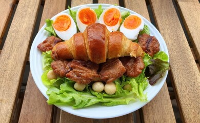 Delicious Croissant with Egg and Meat on Fresh Green Salad Plate