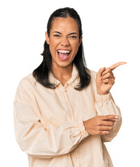 Young Filipina woman pointing with forefingers to a copy space, expressing excitement and desire.