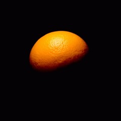 A sun-shaped orange rendered with dramatic chiaroscuro lighting, highlighting strong contrasts and deep shadows