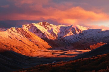 Naklejka premium Majestic snow capped mountains at sunrise illuminating valley below