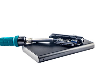 Damaged external drive SSD HDD , transformer soldering iron on white background, electronic...