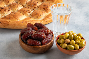 Dates fruit, green olives, Ramadan pita, and water for the iftar table 