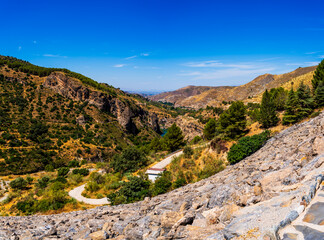 View from Behind Canales Dam Overlooking Rugged Terrain and the Genil River in Granada, Spain