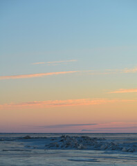 sunset over the ice covered lake