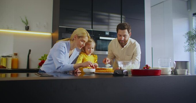 Experience the Joy of Family Members Coming Together to Cook in a Bright and Modern Kitchen Space. Mother farther and daughter enjoys bonding time while cooking delicious cake
