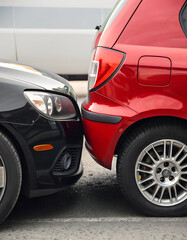 Rear-end car accident involving red and black vehicles in parking lot
