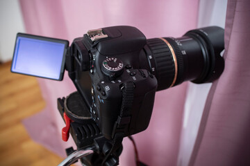 Digital video camera hidden behind pink curtains, spying neighbors Peeping. Spying. Surveillance.   Hidden Camera.   Paparazzi.  Private Detective. Stalker concept