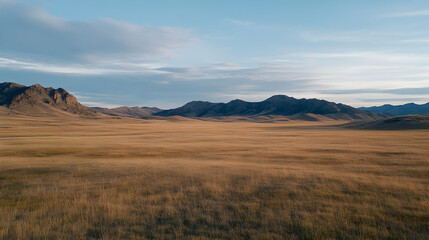 Fototapeta premium Golden plains sunset landscape, vast mountains backdrop, tranquil nature scene; ideal for travel brochures