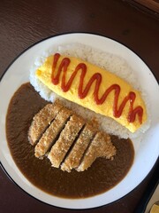 Top view of Japanese curry rice with omelet on a plate placed on the table.