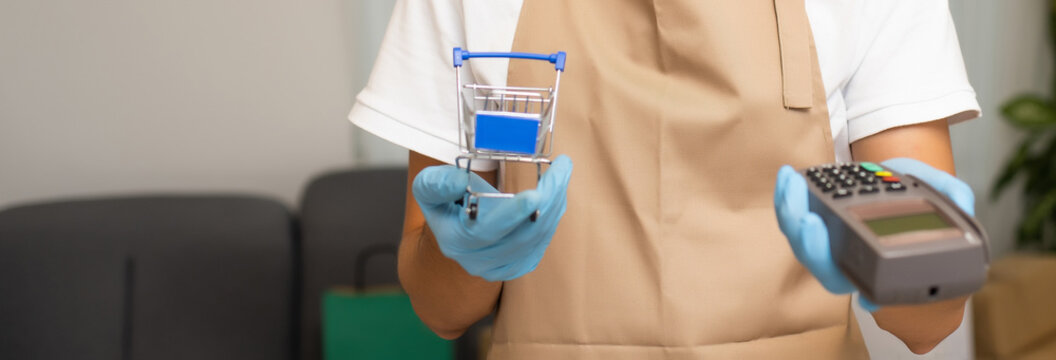 Last step of the shopping is payment. a man holding a card cash register. credit card reader