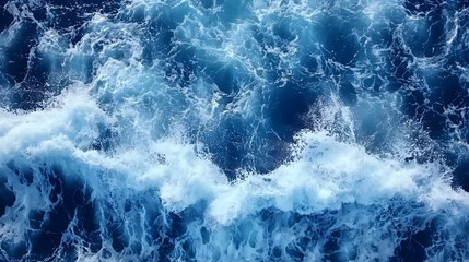 Obraz premium Ocean waves churning, frothy whitecaps, deep blue water, viewed from above. Perfect for travel, nature, or maritime themes