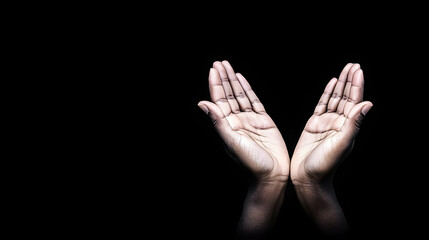 Fototapeta premium Open hands raised in prayer, dark background, hope concept