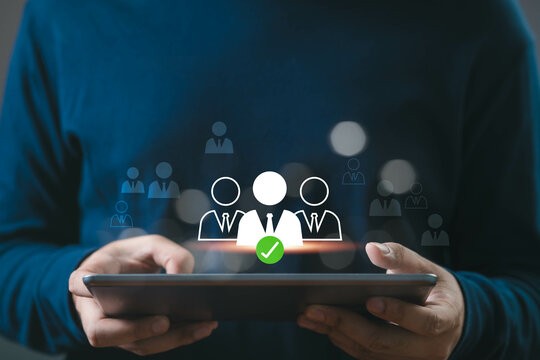 A person holding a tablet with digital icons representing team selection, recruitment, or HR management. Concept of business technology.