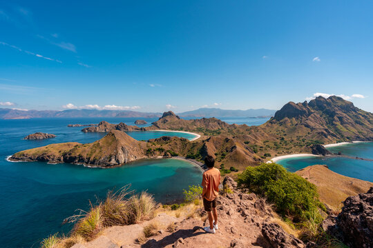 Young man tourist enjoying the beautiful landscape at Padar island in Komodo National Park, Indonesia