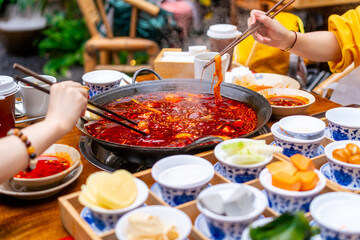 Female tourist eating original mala spicy hot pot in Chongqing, China