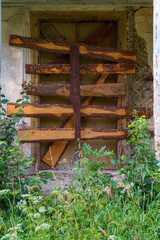 Boarded up doors and windows of an old wooden house. A view of dilapidated housing.