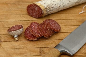 Delightful selection of sliced cured meat with a rustic knife on a wooden cutting board