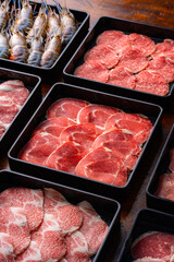 Freshly Sliced Meat and Seafood on Black Trays for Gourmet Dishes
