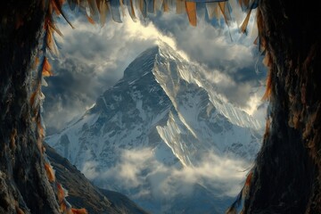 Majestic snow-capped mountain viewed through a rocky cave window under dramatic cloudy sky