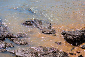 Tranquil Shoreline: Rocky Beach with Gentle Waves and Colorful Tides