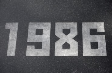Black granite slab with white numbers 1986 on it