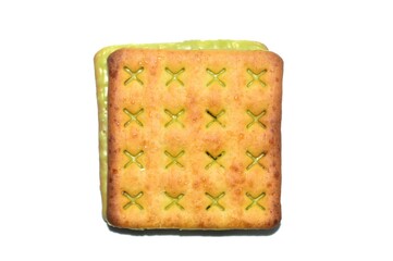 A close-up of a square biscuit with a green filling, isolated on a white background
