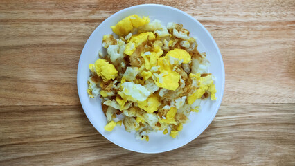 Healthy breakfast with scrambled eggs on the wooden table. 