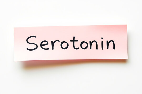 Text serotonin on pink note on white background