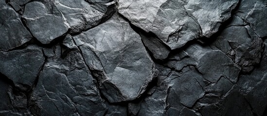 Textured dark slate rock surface background with natural patterns and variations available for layering or incorporation into designs Copy Space