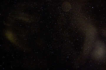 Starry sky with yellowish highlights around