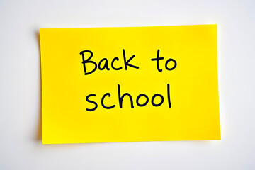 Text Back to school on yellow note on white background