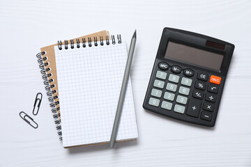 Top view photo of office accessories calculator, notebook and pencil on white background with empty...